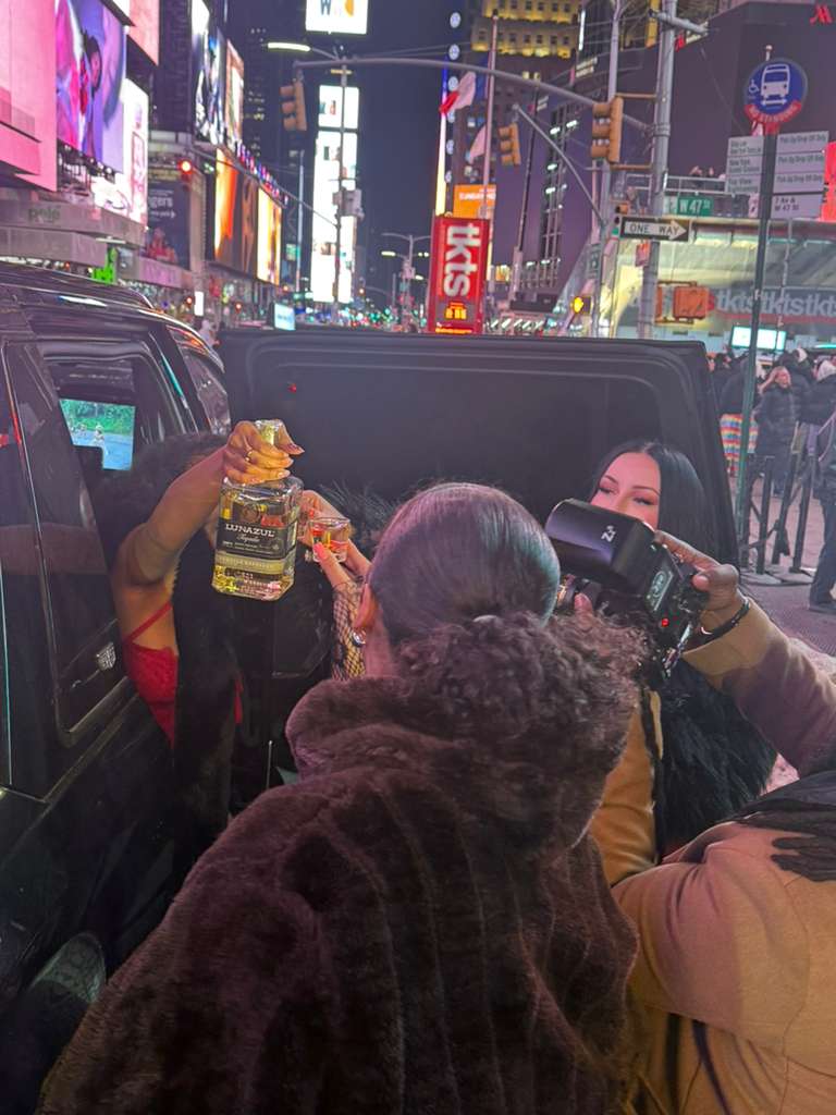 Professional chauffeur in black suit opening the door of a luxury black SUV for VIP client in Manhattan